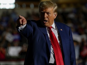 caption: Former President Donald Trump gestures as he enters the Erie Insurance Arena in Erie, Pa., for a political rally while campaigning for the GOP nomination on July 29.