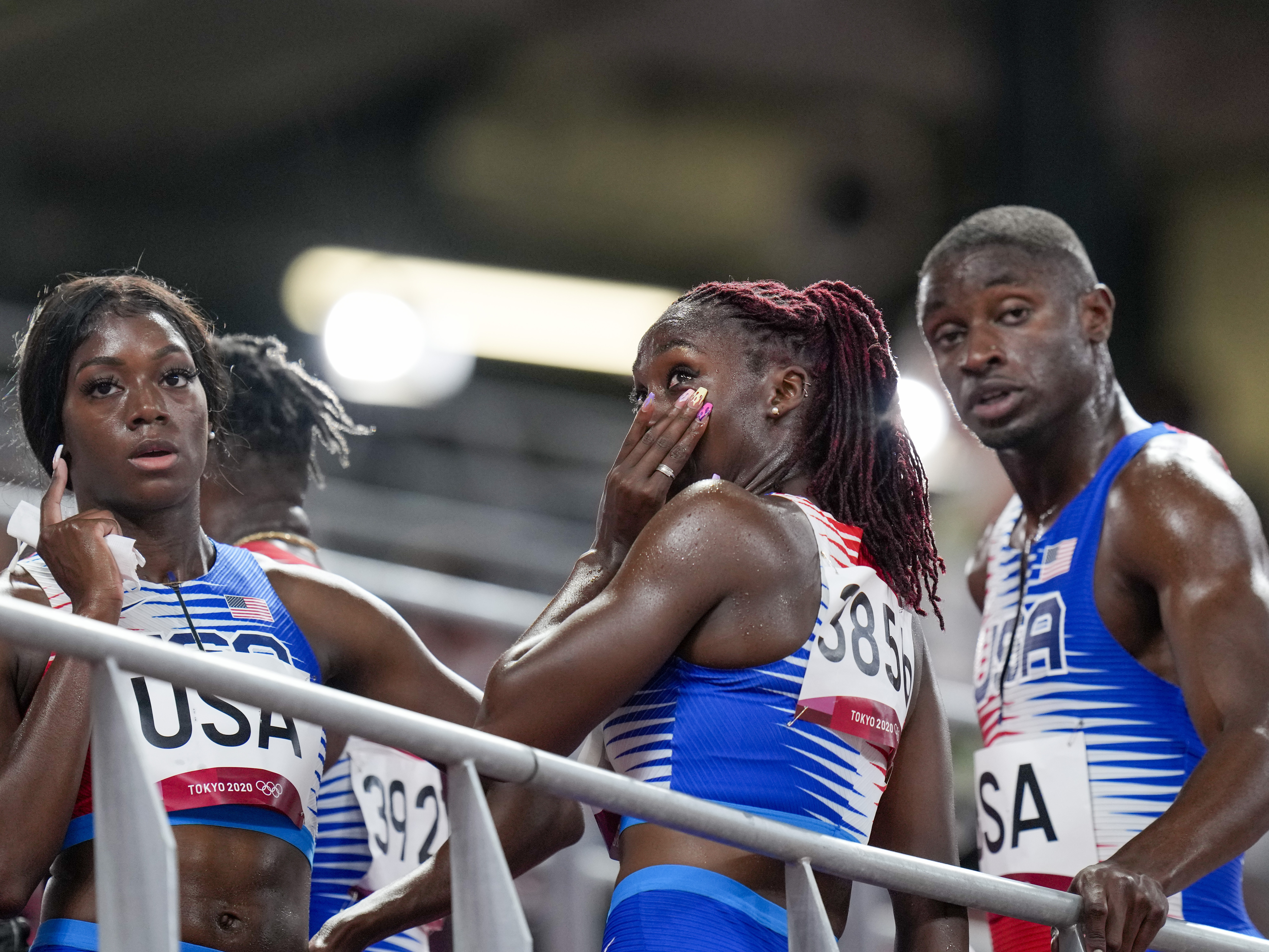 caption: U.S. sprinter Lynna Irby wipes away a tear Friday after the 4x400-meter mixed relay at the Tokyo Olympics.