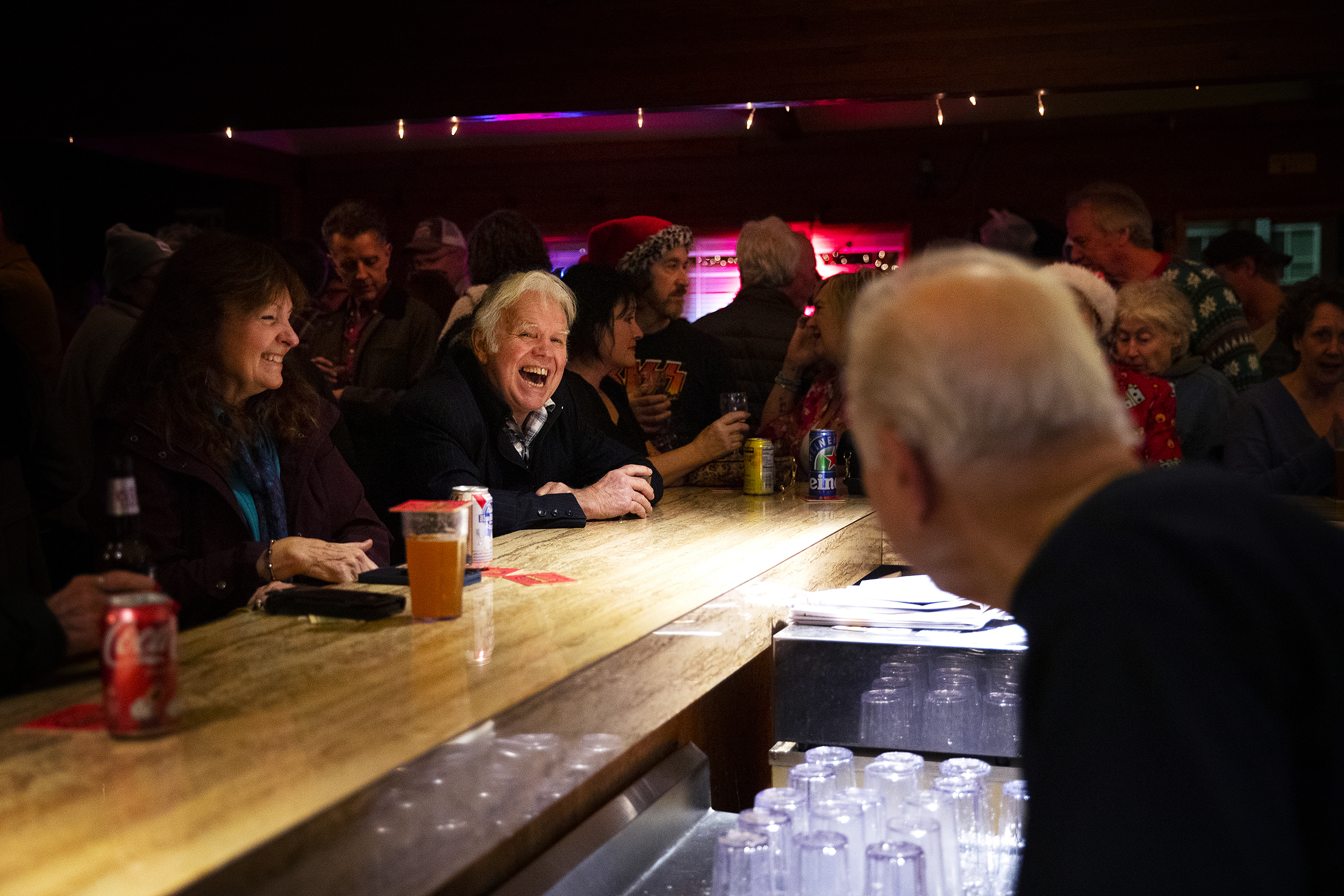 caption: Ron W. Bailey smiles and laughs with John Spaccarotelli, 94-year-old owner and bartender, on the last night of business for the Shanty Tavern on Friday, December 19, 2025, in Lake City. 