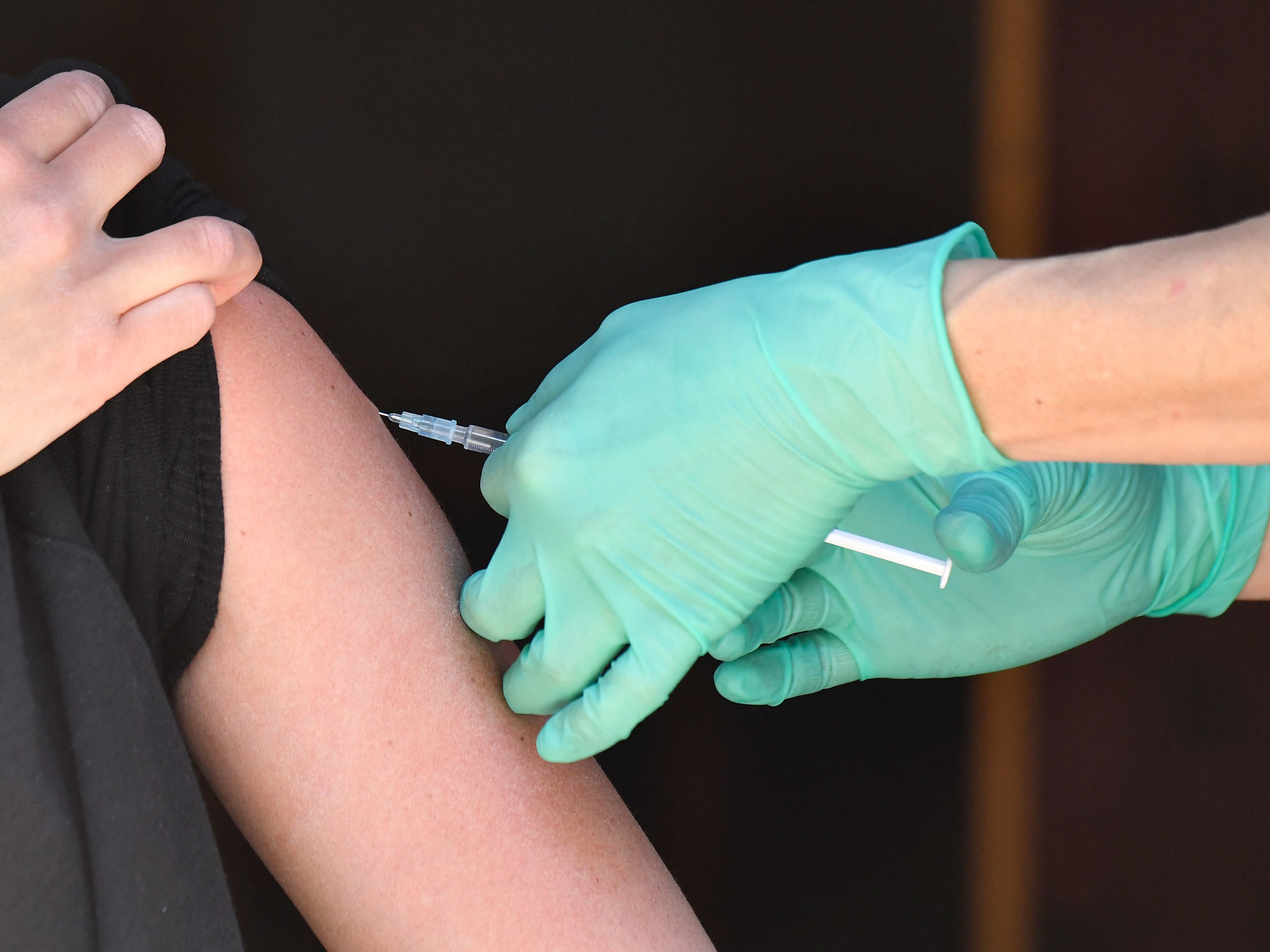 caption: A medical assistant administers the Johnson & Johnson Covid-19 vaccine at the Revolte Bar and Pub in Berlin's Friedrichshain district on May 30, 2021.