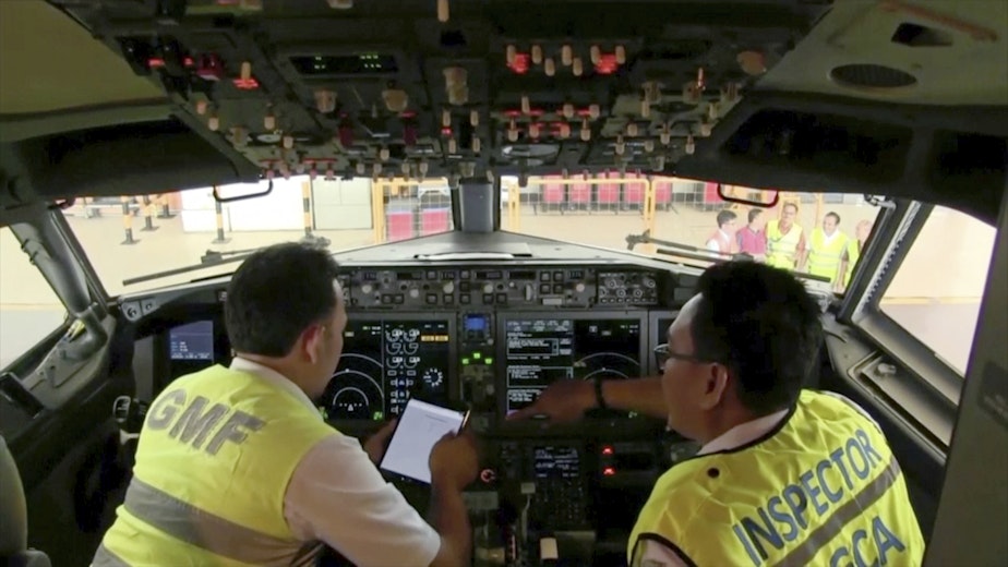 caption: In this image from video taken on Tuesday, March 12, 2019, officials make inspection inside the cockpit of a Boeing 737 Max 8 aircraft is in hangar at Garuda Maintenance Facility at Soekarno Hatta airport, Jakarta. The Indonesian Transport Ministry on Tuesday conducted inspections of 737 Max 8 aircraft owned by Garuda Indonesia and Lion Air. 