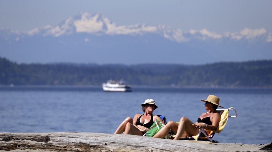 caption: Beach-goers soak up the sun in view of the Puget Sound and Olympic mountains behind during a likely third day in a row of record high temperatures Tuesday, April 19, 2016, in Seattle.