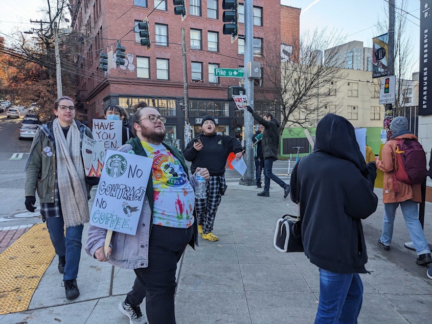 caption: Starbucks workers picket outside Starbucks in Seattle.