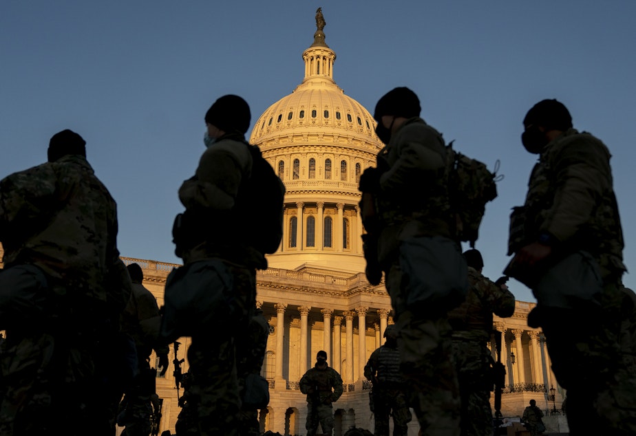 caption: Members of the National Guard gather outside the U.S. Capitol — part of a massive boost to security after the riot last Wednesday, and leading up to Inauguration Day.