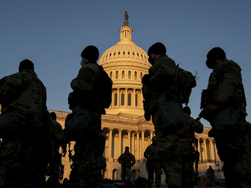caption: Members of the National Guard gather outside the U.S. Capitol — part of a massive boost to security after the riot last Wednesday, and leading up to Inauguration Day.