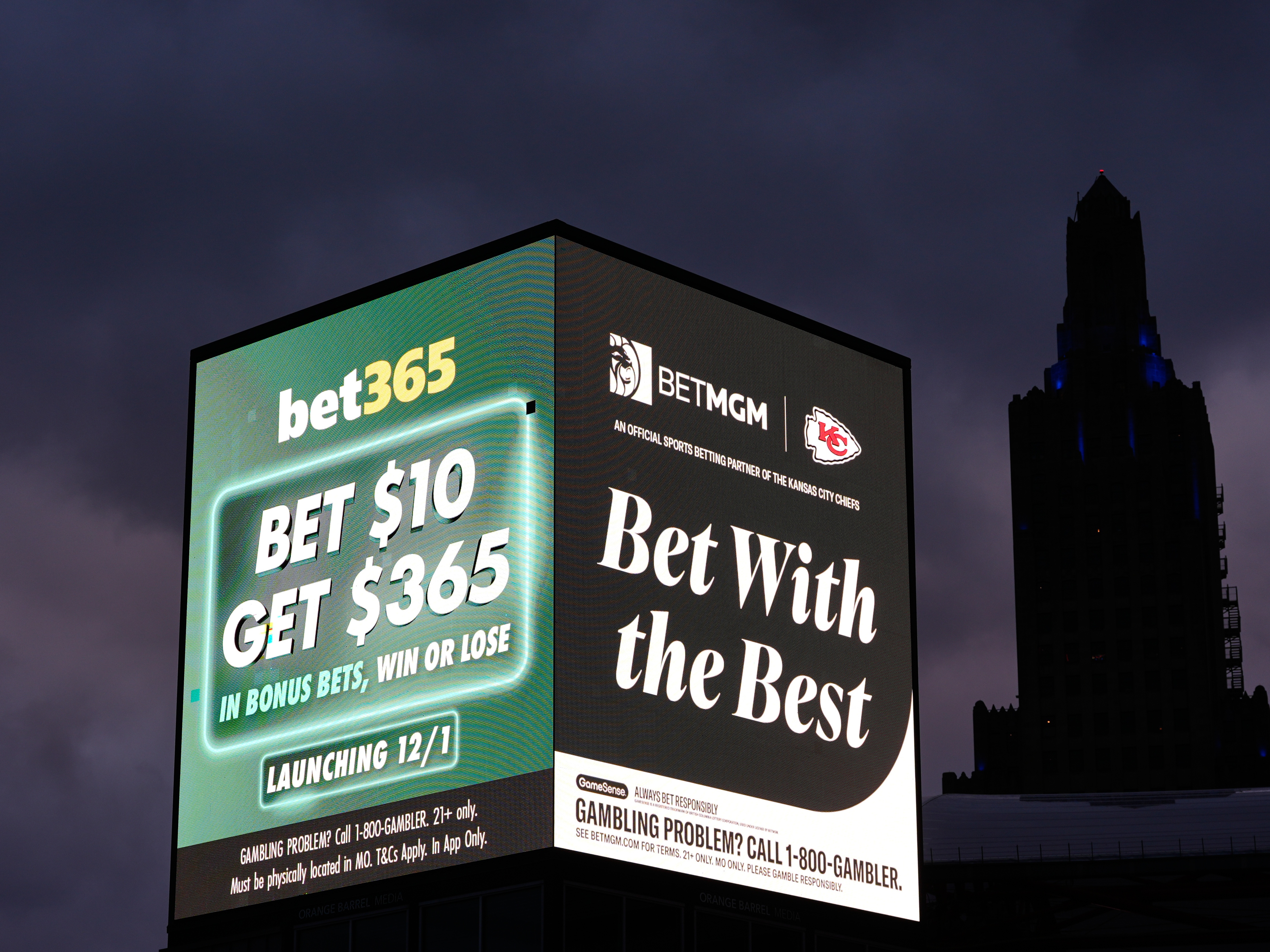 caption: Advertisements for sports betting apps are seen in downtown Kansas City, Mo., in November.