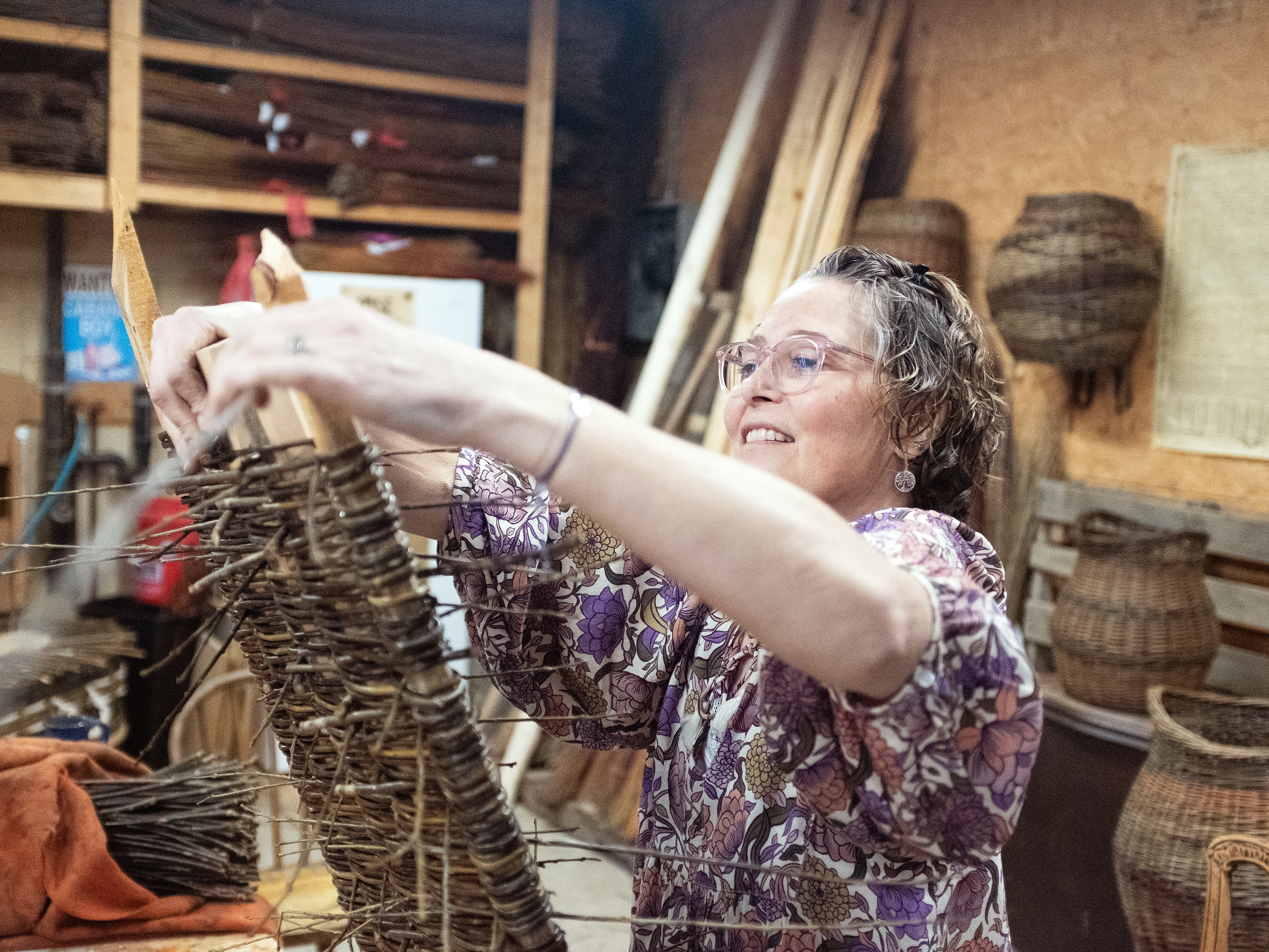 caption: MaddyChristine Hope Brokopp weaves the bottom of a burial tray. Brokopp enlisted her friends to weave her tray after a cancer diagnosis.