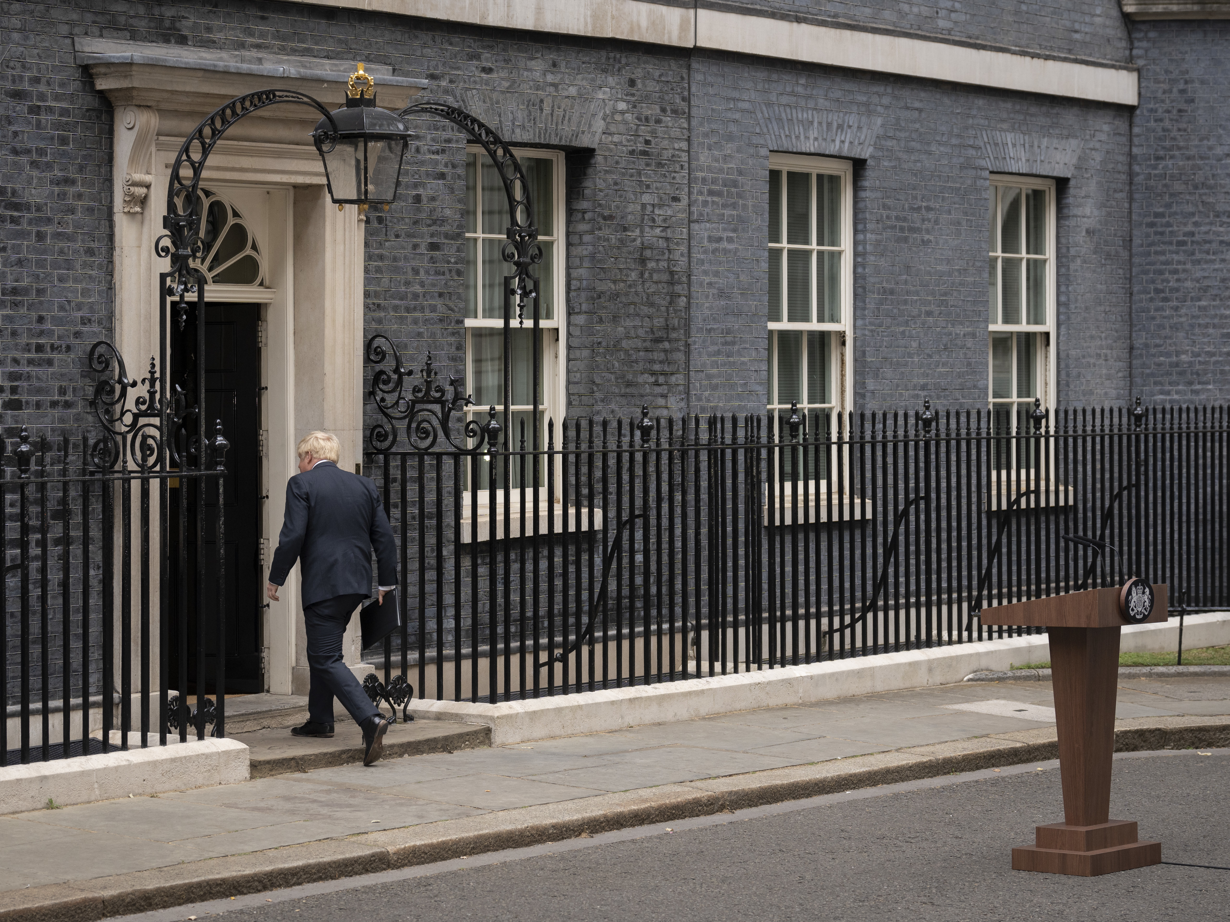 caption: Prime Minister Boris Johnson walks back into 10 Downing St. after announcing his resignation as Conservative Party leader on Thursday.