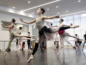 caption: Ballet dancers in Shanghai rehearse while wearing masks on March 2. A virus first identified in December has altered daily life and public spaces around the globe.
