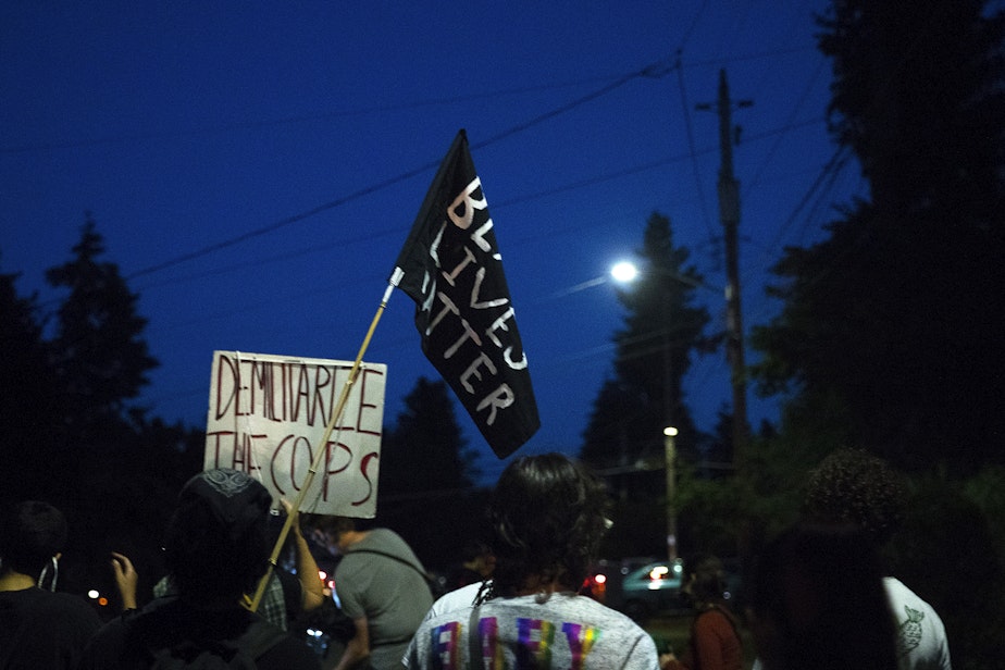 caption: The Everyday March group heads toward Seattle City Councilmember Debora Juarez's home in an effort to have a dialogue about racial justice and police brutality on Tuesday, August 4, 2020, in the Victory Heights neighborhood of Seattle. "It is on us," said organizer Tealshawn Turner. "It is our duty, our obligation, our responsibility to come out here and stand up for the next generation. You have to speak life into these children." 
