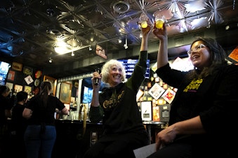 caption: Mari Kemper, left, and Leslie Shore, right, cheers after speaking to a crowd gathered to celebrate "Women in Beer," an annual fundraiser for the Rose Ann Finkel Diversity in Brewing Fund on Thursday, March 21, 2024, at the Pike Brewing Company in Seattle. 
