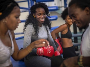 caption: Boxer Legnis Cala, center, talks with fellow female boxers during a training session in Havana, Cuba, Monday, Dec. 5, 2022. Cuban officials announced on Monday that women boxers would be able to compete for the first time ever.