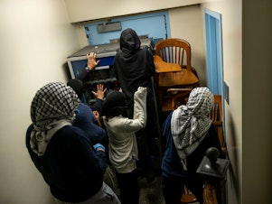caption: Demonstrators supporting Palestinians in Gaza barricade themselves inside Hamilton Hall, where the office of the dean is located, on Tuesday in New York City.
