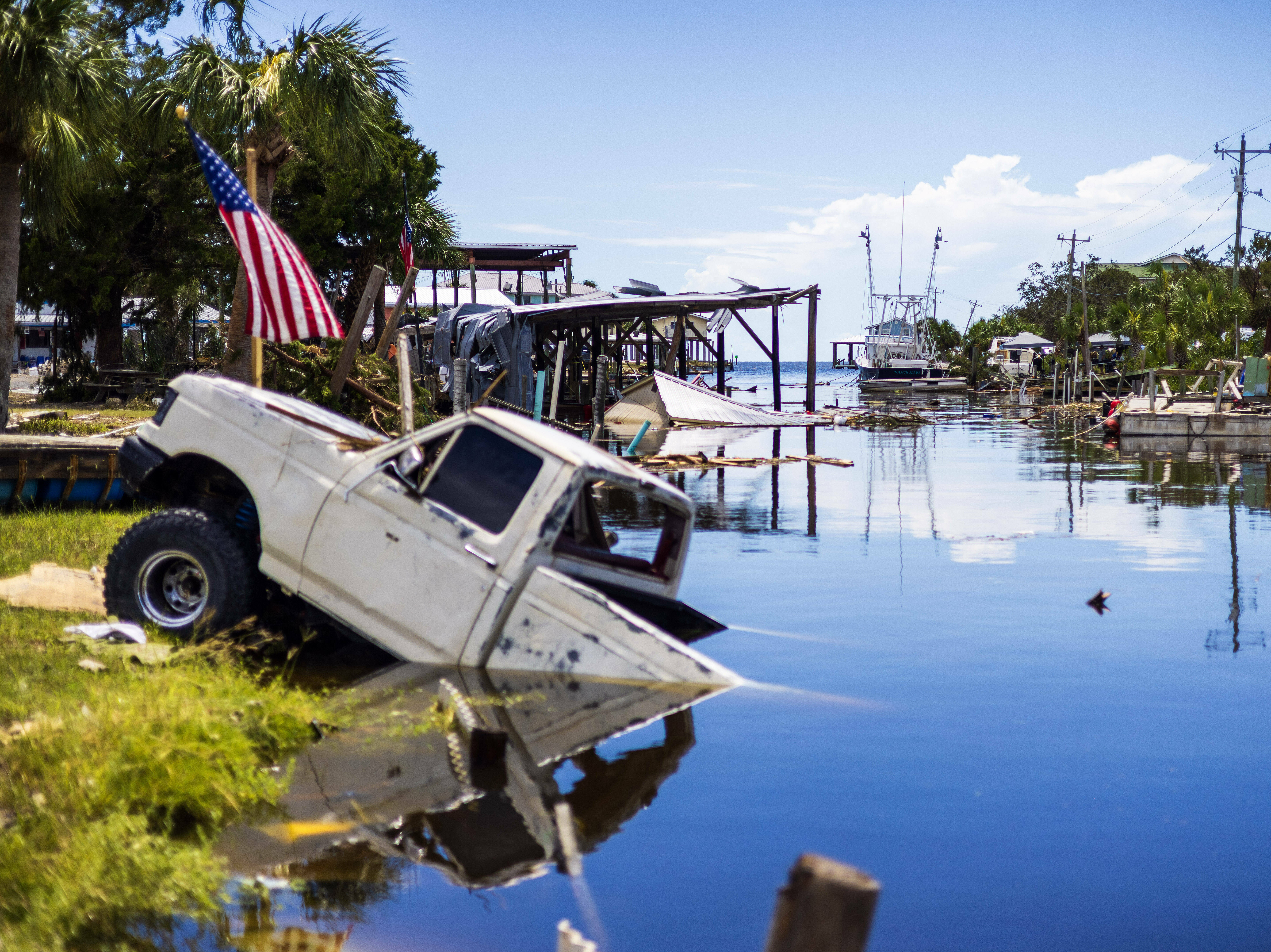 caption: A pick up truck sinks into a canal.