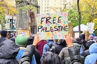 caption: A protestor holds a handmade sign that reads, "FREE PALESTINE," at a rally in Seattle on Tuesday, October 17, 2023.