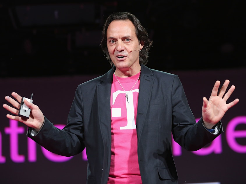 caption: John Legere, CEO and president of T-Mobile USA, sports one of his distinctive magenta T-shirts. Its parent, Deutsche Telekom, is telling a small insurance company not to use the color.