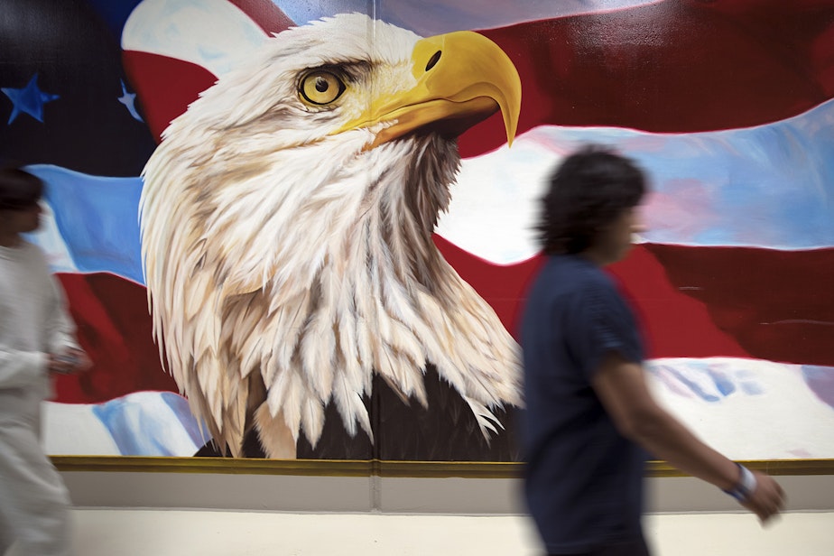 caption: Dozens of murals hang on the walls at the Northwest Detention Center. They're painted by detainees, and the designs must be approved by staff. Painting is also considered a voluntary job, and the artists are paid $1 per day for their work.
