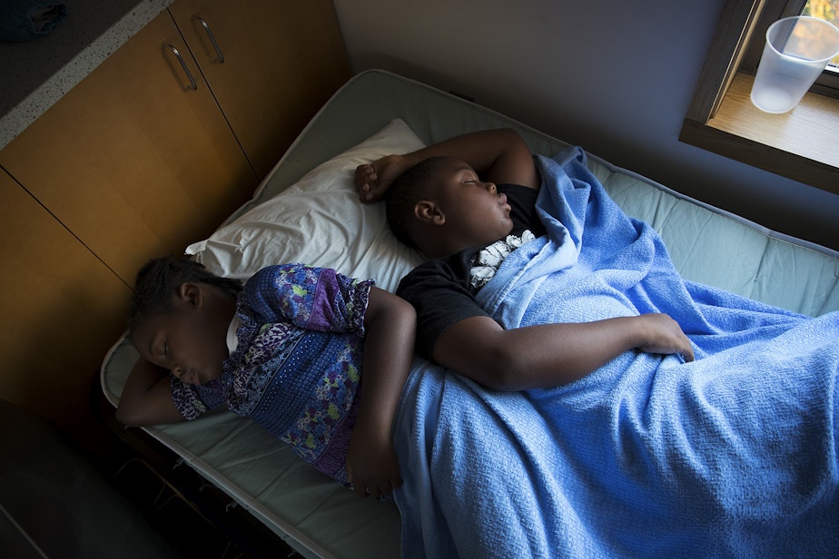 caption: Siblings Matthew, 9, right, and Mariah Hicks, 7, sleep on a cot on Tuesday, August 29, 2017, at Swedish First Hill Birth Center on Broadway St., in Seattle. 