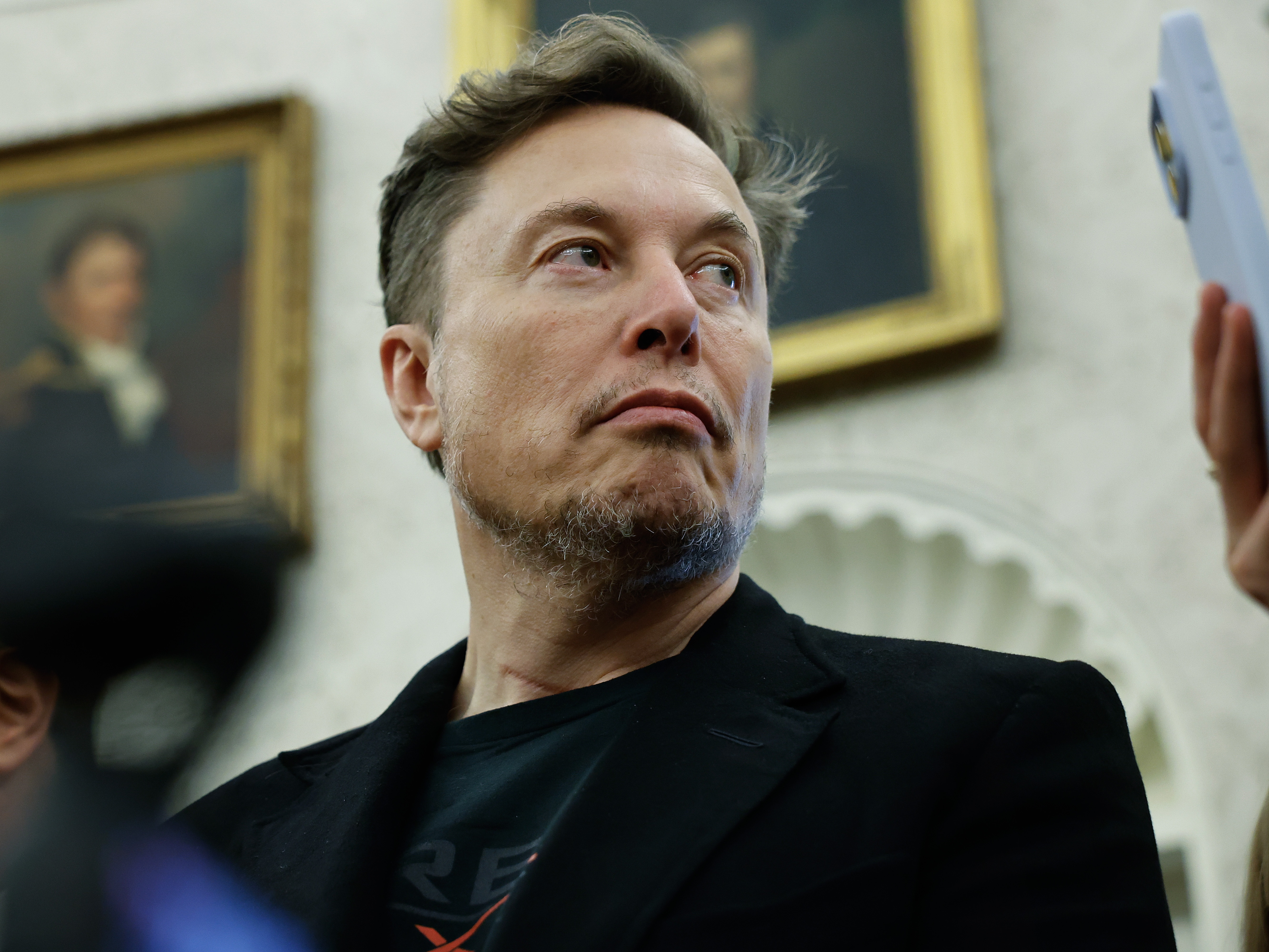 caption: Elon Musk listens during a bilateral meeting between President Trump and South Africa President Cyril Ramaphosa at the White House on May 21, 2025. Musk announced this week that he was leaving the Trump administration and returning to focus on his businesses.