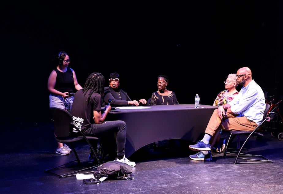 caption: From left to right: KUOW reporter Mike Davis, KUOW producer Noel Gaska (standing), office of arts and culture director royal alley-barnes, executive director of Nu Black Arts West Theatre Kibibi Monie, LHPAI operations manager Sandra Boas-Dupree, LANGSTON executive director Tim Lennon