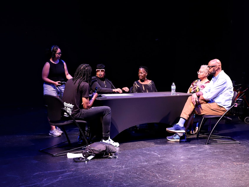 caption: From left to right: KUOW reporter Mike Davis, KUOW producer Noel Gaska (standing), office of arts and culture director royal alley-barnes, executive director of Nu Black Arts West Theatre Kibibi Monie, LHPAI operations manager Sandra Boas-Dupree, LANGSTON executive director Tim Lennon