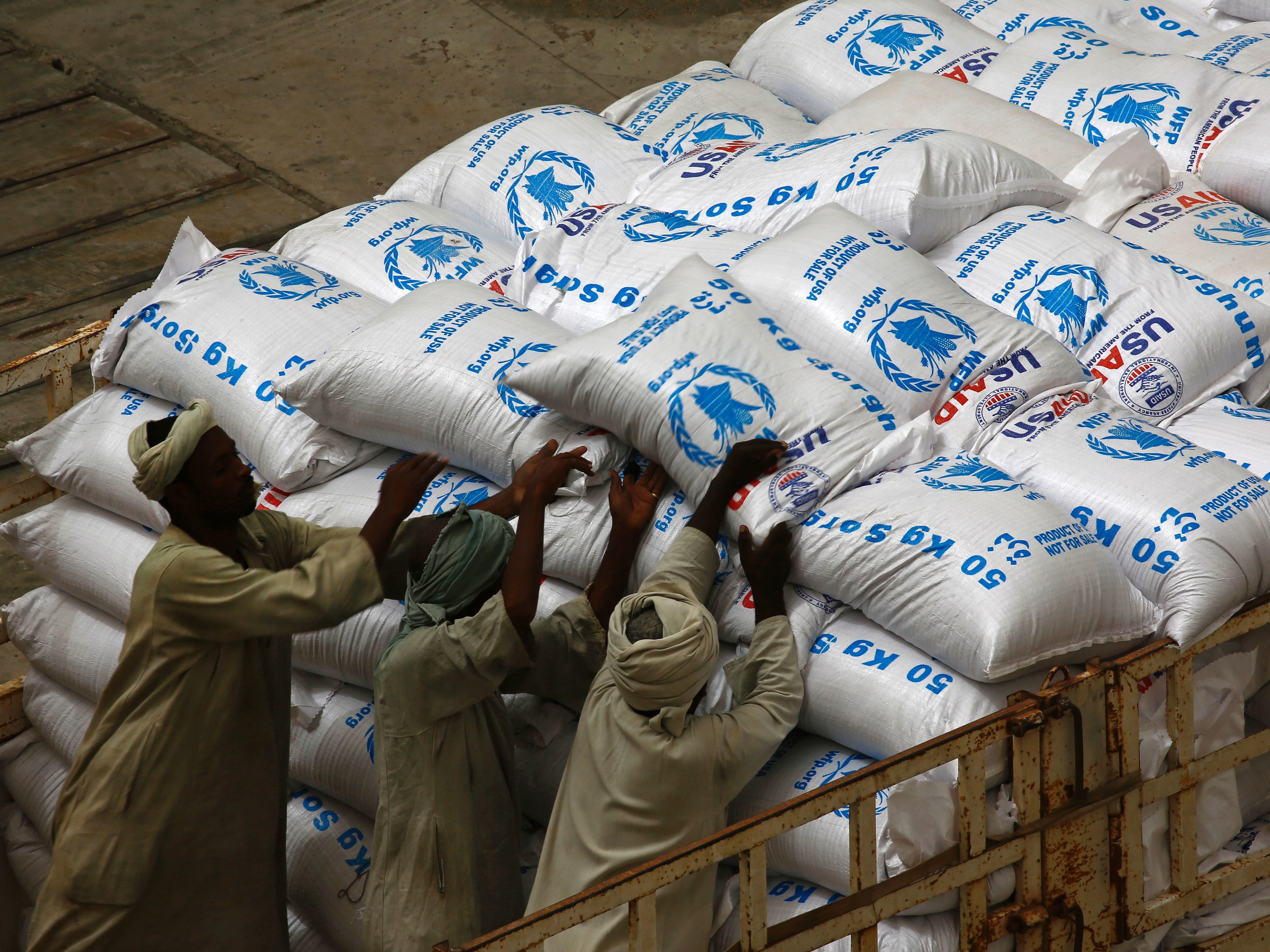caption: Sudanese workers offload U.S. aid destined for South Sudan from the World Food Programme (WFP) at Port Sudan on March 19, 2017.