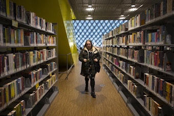 caption: Kara Peters walks through the Seattle Public Central Library to her desk before starting her shift on Wednesday, January 22, 2020, in Seattle.