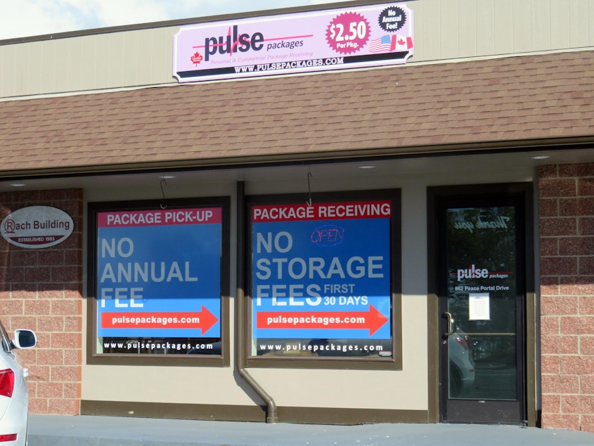 caption: A steady stream of cars with British Columbia license plates stop by the Pulse Packages storefront just off the interstate in Blaine.