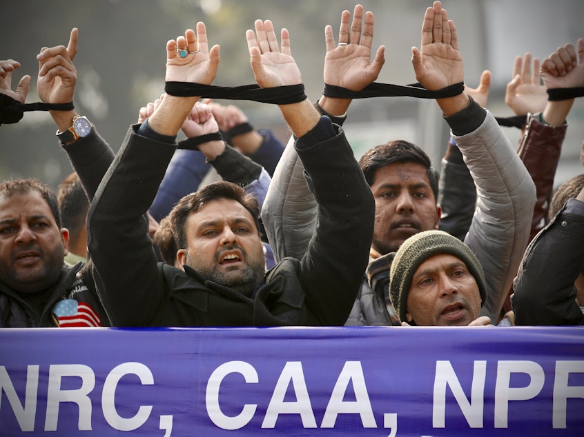 caption: Indians raise their tied hands and shout slogans during a protest against the Citizenship Amendment Act in New Delhi, India, Dec. 27, 2019. Prime Minister Narendra Modi's government on Monday announced rules to implement a 2019 citizenship law that critics say is discriminatory against Muslims, weeks before the Hindu nationalist leader will seek a third term in office.