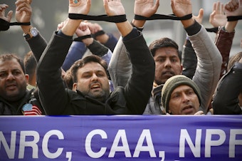 caption: Indians raise their tied hands and shout slogans during a protest against the Citizenship Amendment Act in New Delhi, India, Dec. 27, 2019. Prime Minister Narendra Modi's government on Monday announced rules to implement a 2019 citizenship law that critics say is discriminatory against Muslims, weeks before the Hindu nationalist leader will seek a third term in office.