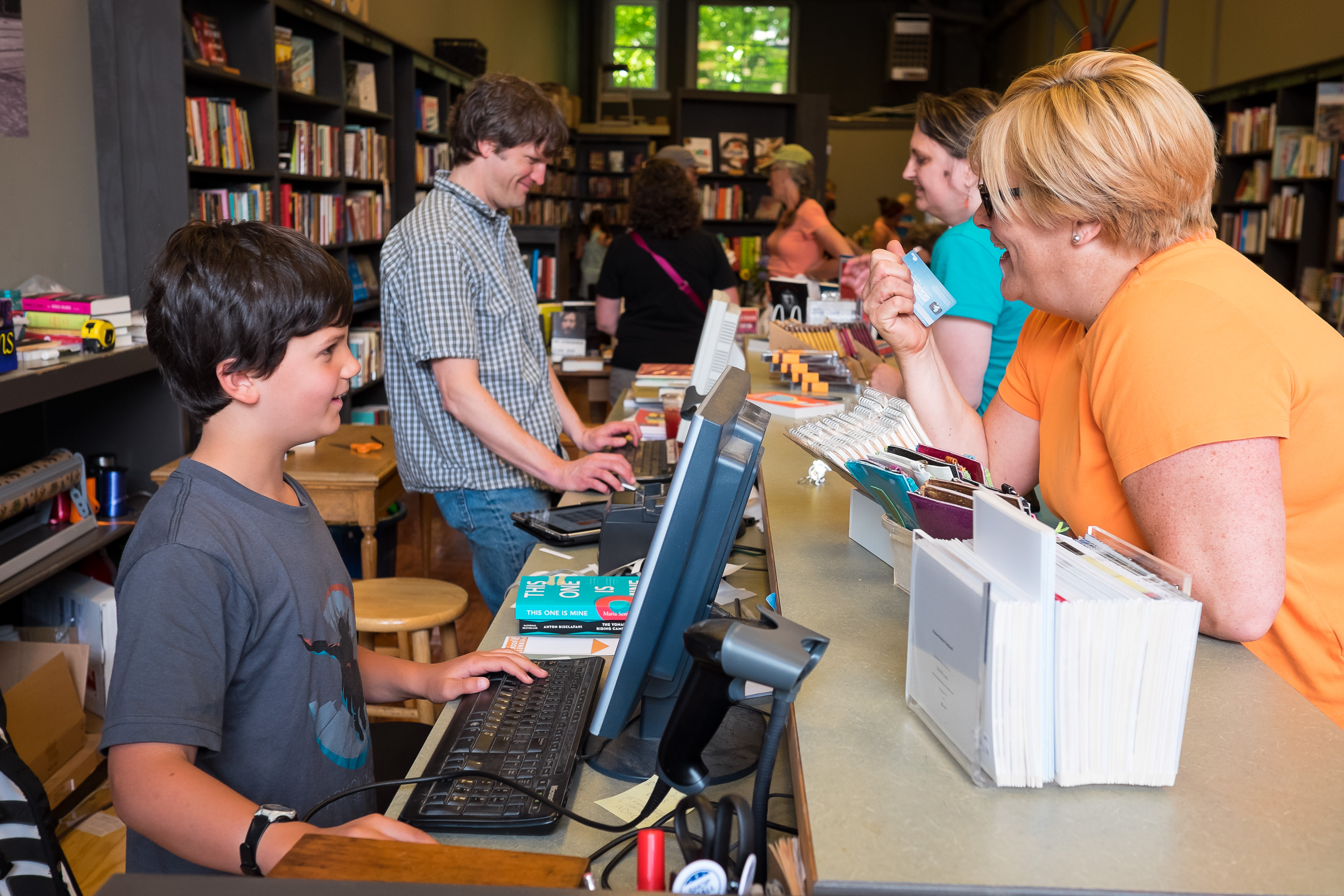 caption: Tom Nissley and his son, Henry, check out customers on the opening day of Phinney Books, in June 2014. The shop is one of 33 Seattle-area locations participating in Independent Bookstore Day on April 25, 2026, just ahead of the store's 12th birthday.