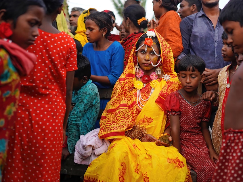 caption: A 14-year-old schoolgirl in Bangladesh poses with friends and neighbors on her wedding day. A new UNESCO report looks at progress — and the lack thereof — in ending child marriage.