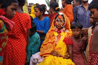 caption: A 14-year-old schoolgirl in Bangladesh poses with friends and neighbors on her wedding day. A new UNESCO report looks at progress — and the lack thereof — in ending child marriage.