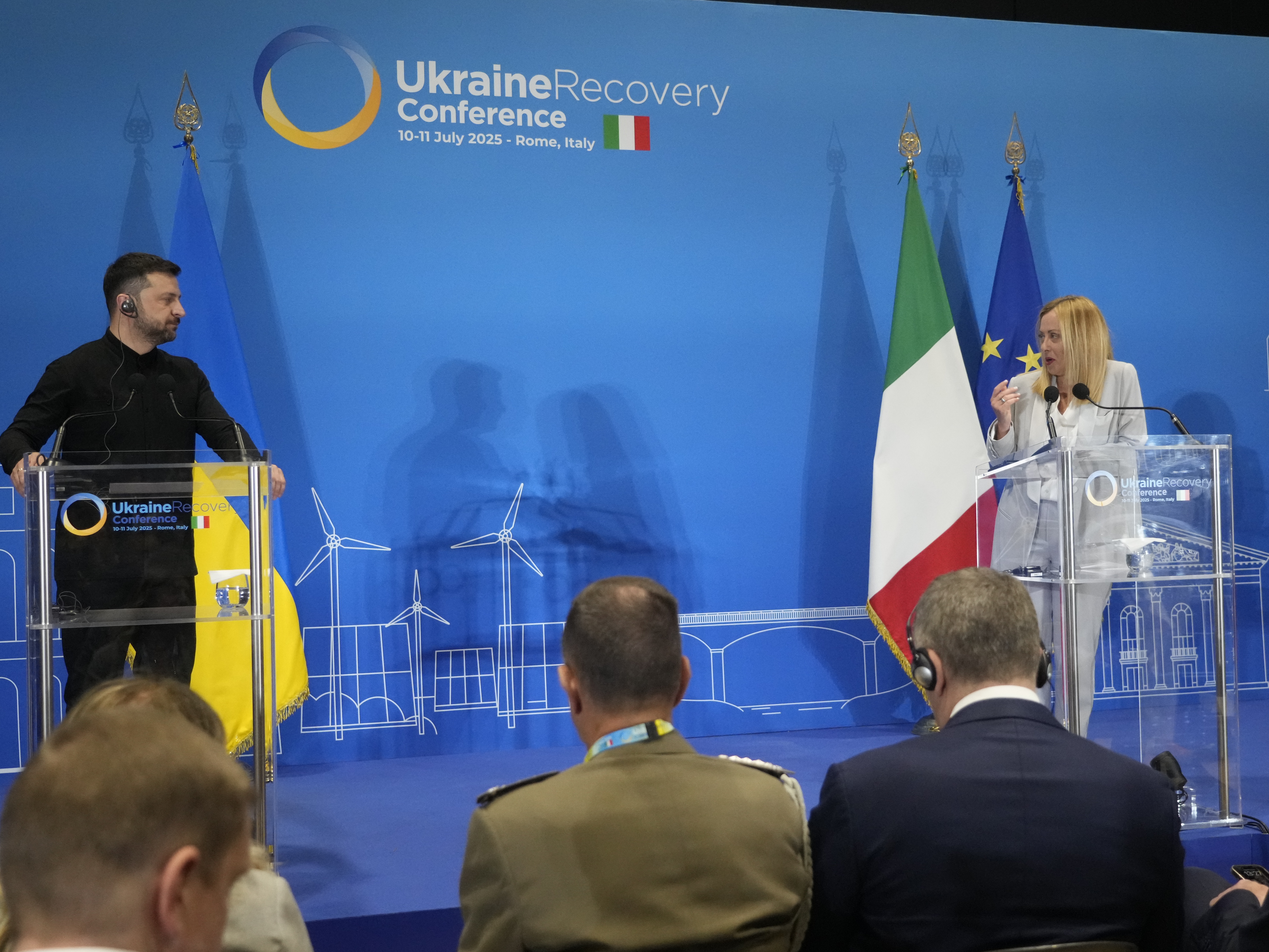 caption: Ukraine's President Volodymyr Zelenskyy and Italian Prime Minister Giorgia Meloni speak with media reporters during the Ukraine Recovery Conference at La Nuvola convention center in Rome on Thursday.