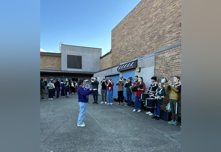 caption: Members of the Shorecrest High School band played their school fight song as more than a hundred people lined up around the block to attend the school board meeting. The Shoreline School District is considering trimming about $14 million from its budget next year, and arts programs and other extracurricular activities may be subject to cuts.