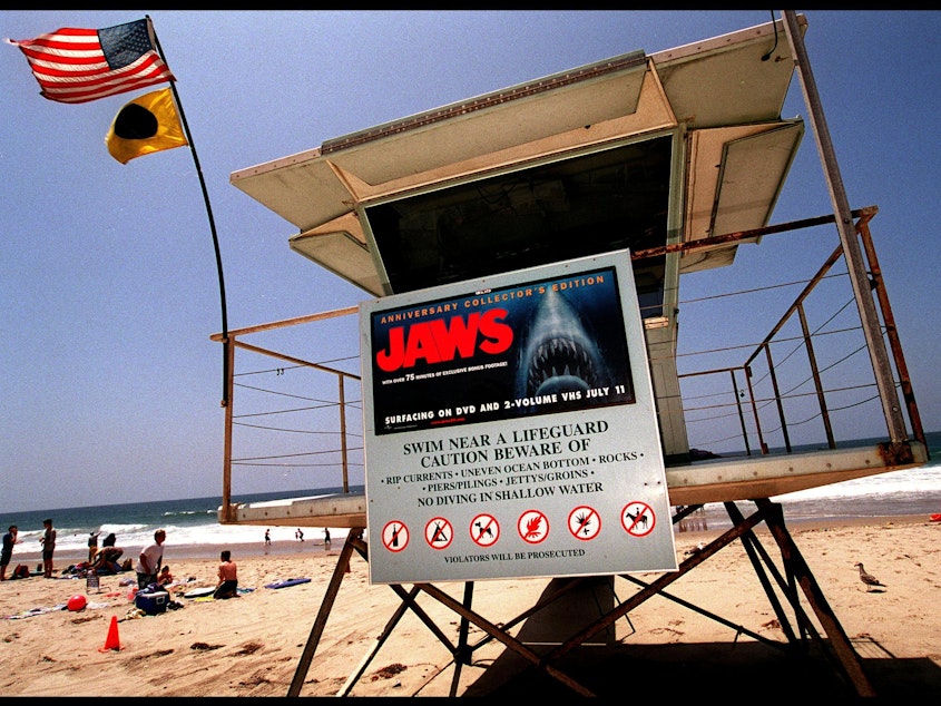 caption: A poster advertising the anniversary collector's edition of the movie <em>Jaws</em> is posted on a lifeguard tower in 2000 on Zuma Beach in Malibu, Calif.