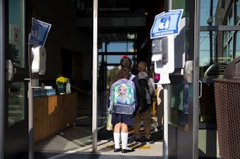 caption: Students enter Mount View Elementary School on the first day of school, Thursday, September 2, 2021, in Seattle. 
