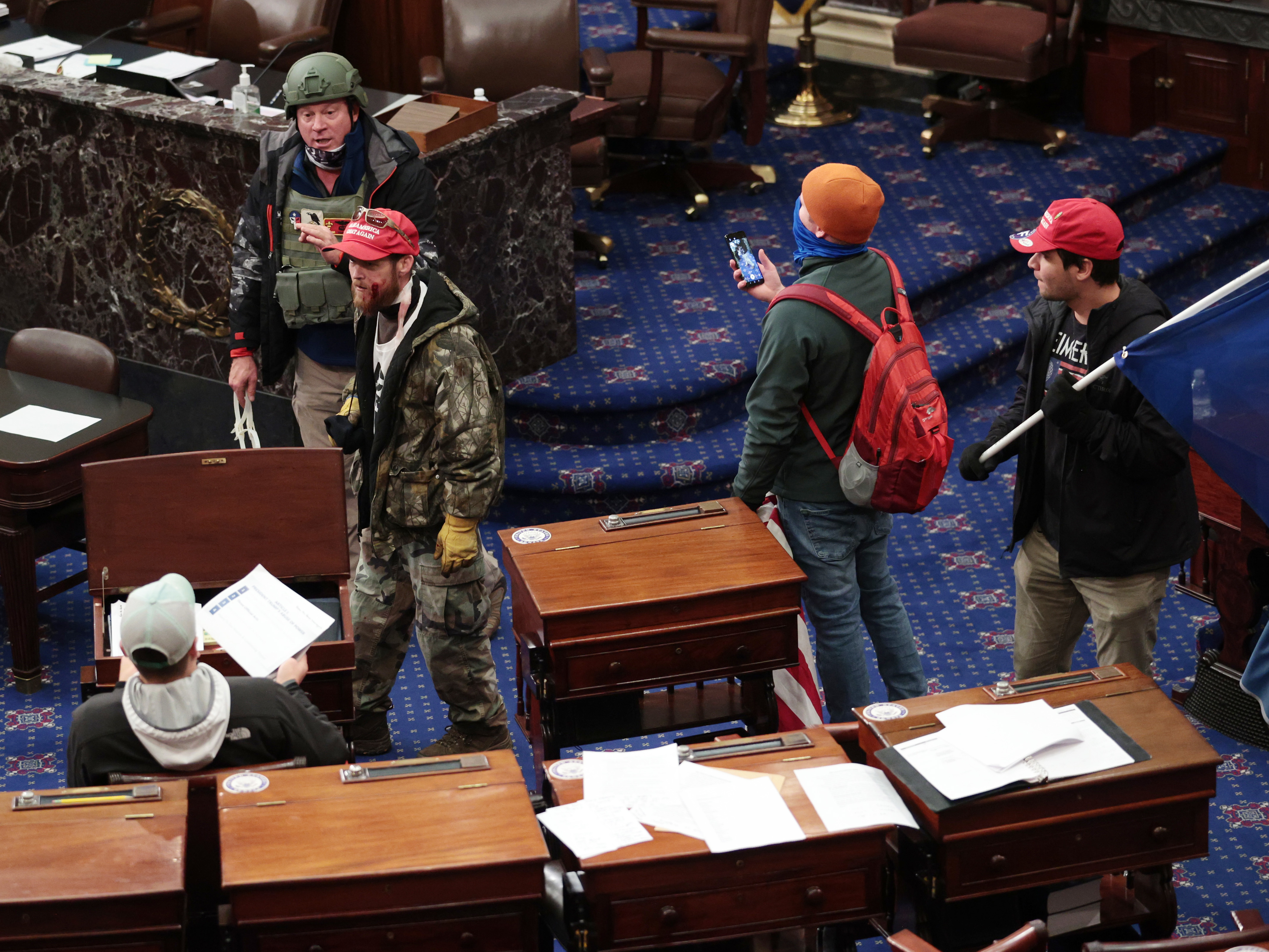 caption: Larry Rendall Brock Jr., an Air Force veteran, is seen inside the Senate Chamber wearing a military-style helmet and tactical vest during the rioting at the U.S. Capitol. Federal prosecutors have alleged that before the attack, Brock posted on Facebook about an impending "Second Civil War."