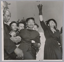 caption: Mamie Till-Mobley (center) at the funeral of her 14-year-old son, Emmett Till, who was kidnapped, tortured, and shot to death by two white men while visiting family in Drew, Mississippi, in 1955. Till Mobley's decision to hold an open-casket funeral displaying her son’s mutilated body generated worldwide attention and outrage over racial violence faced by Black Americans in the Jim Crow South.