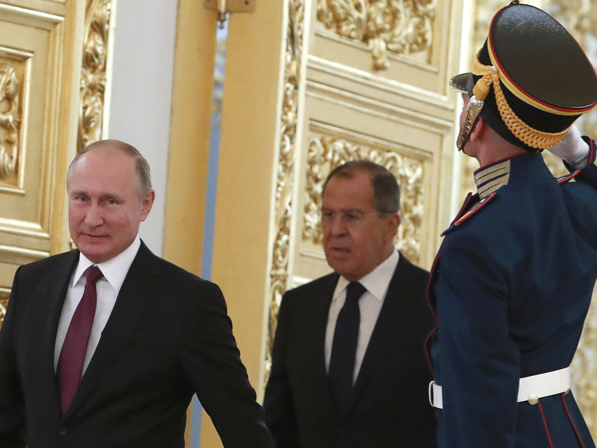 caption: Russian President Vladimir Putin and Foreign Minister Sergei Lavrov walk past honour guards at the Kremlin in Moscow. U.S. sanctions are targeting Putin and a handful of individuals believed to be among his closest advisors.