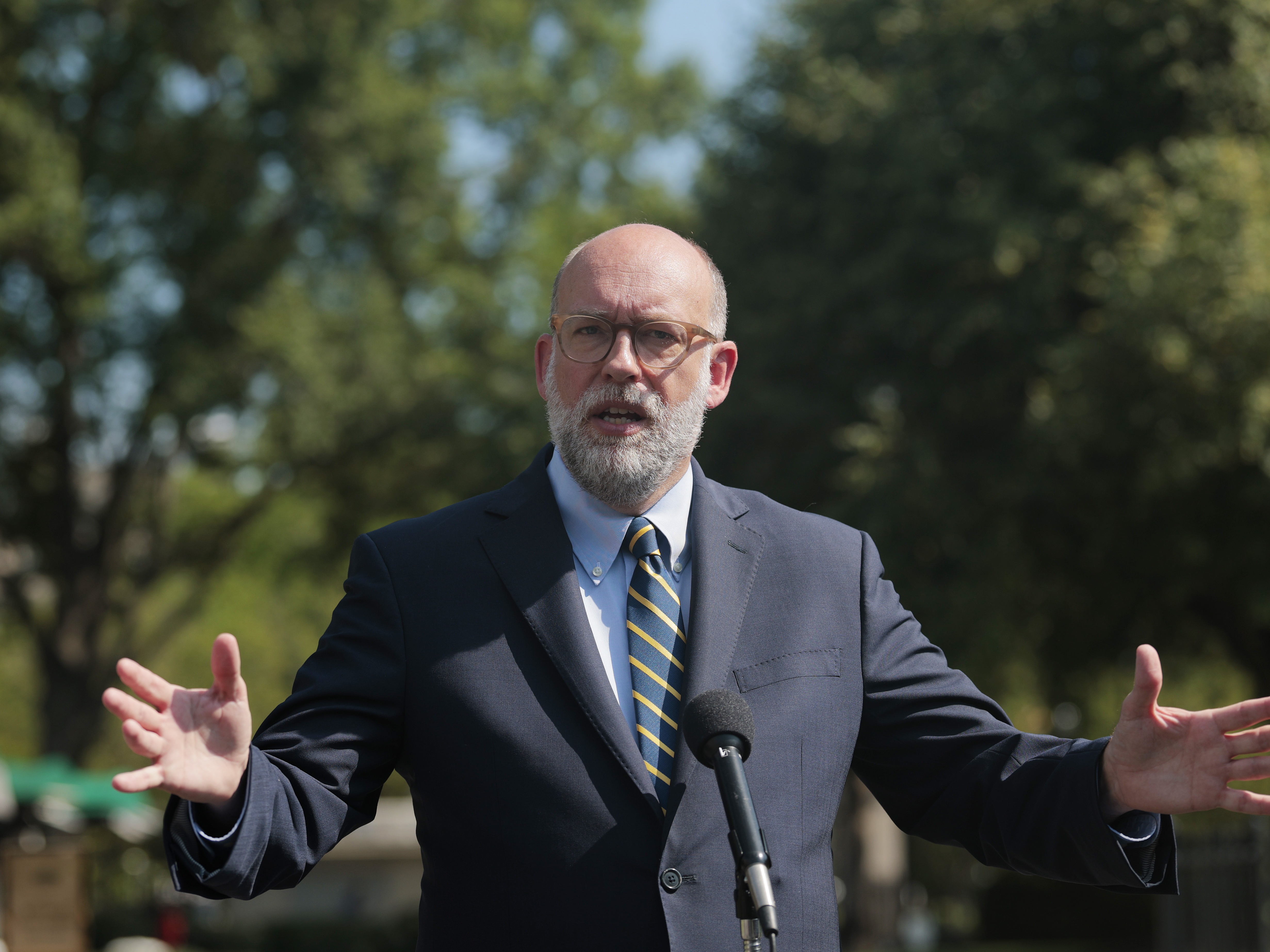 caption: Russell Vought, director of the Office of Management and Budget, speaks with reporters outside of the West Wing of the White House on July 17.