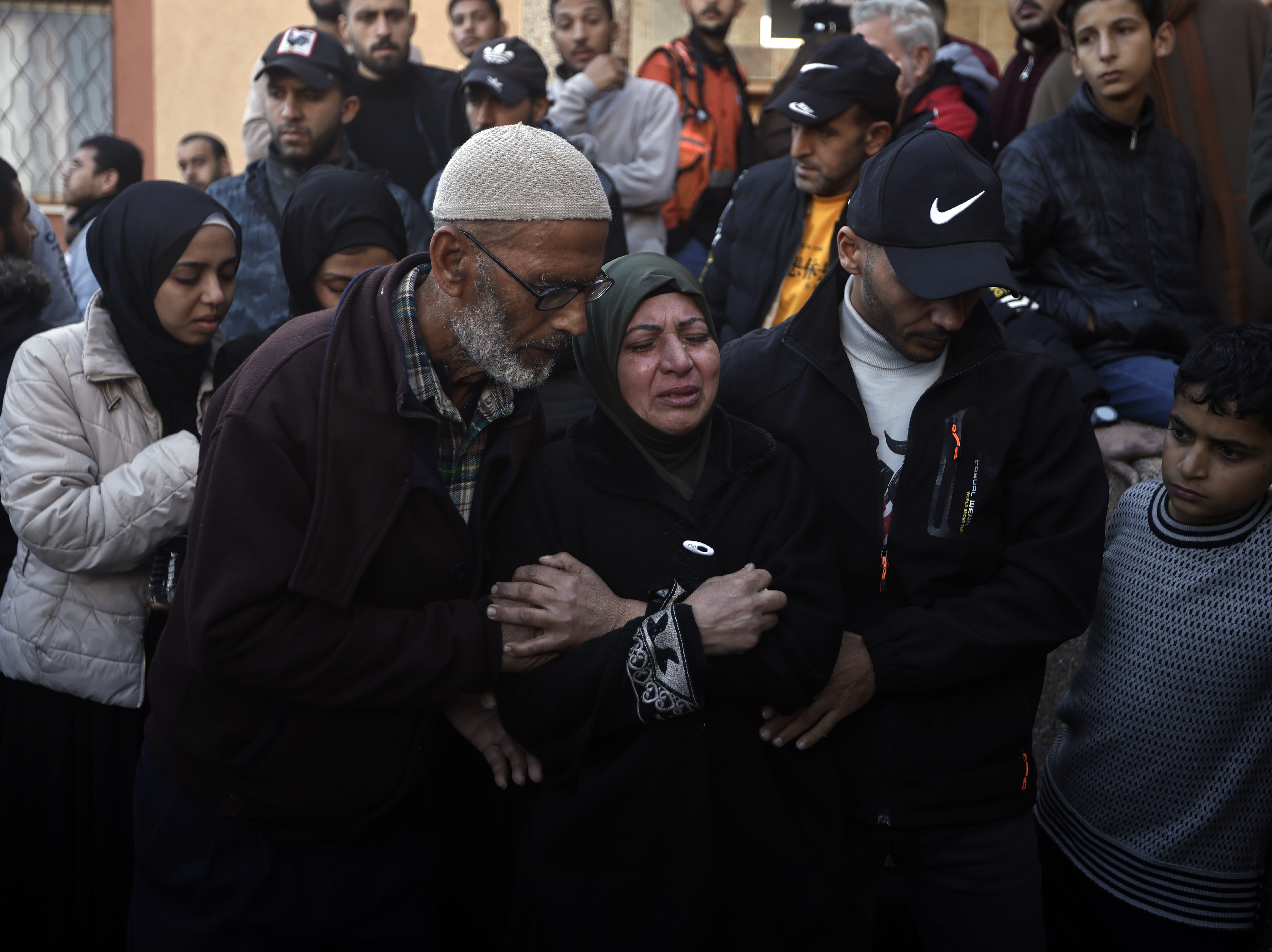 caption: Palestinians mourn relatives killed in the Israeli bombardment of the Gaza Strip outside a morgue in Khan Younis on Sunday.