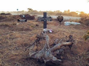 caption: An illegal roadside graveyard in northeastern Namibia. People in the townships surrounding Rundu, a town on the border to Angola, are too poor to afford a funeral plot at the municipal graveyard — and resorted to burying their dead next to a dusty gravel road just outside of the town.