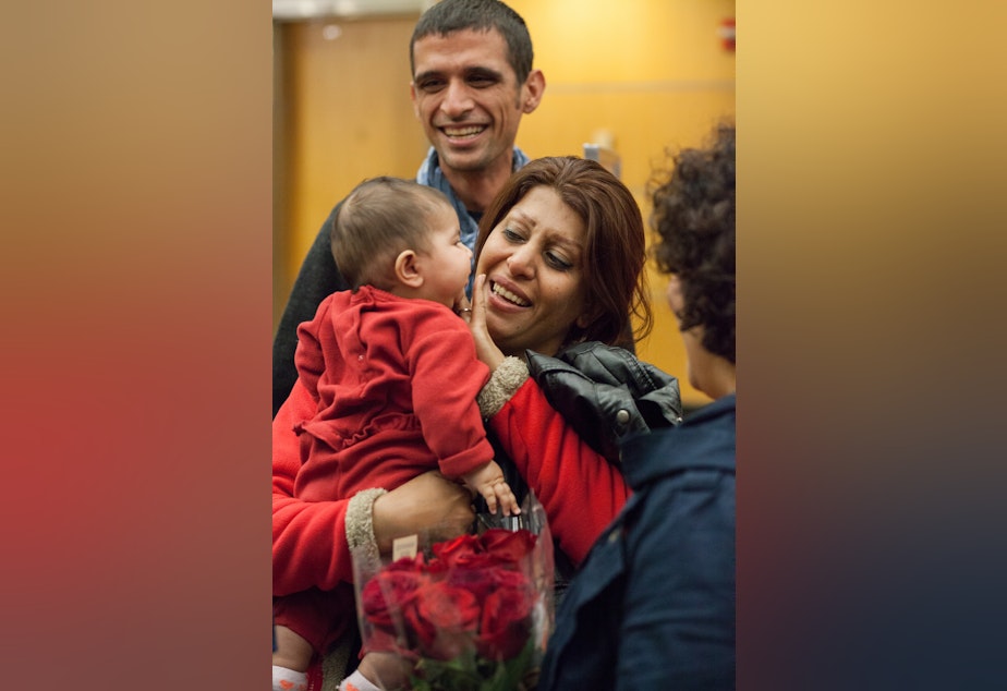 caption: A refugee family from Iran arrives at SeaTac Airport in 2015