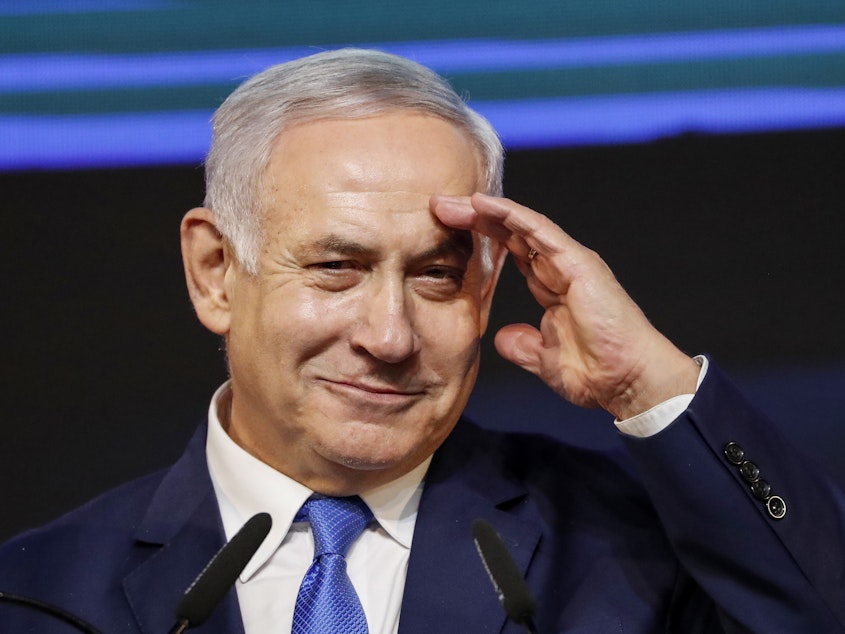 caption: Israeli Prime Minister Benjamin Netanyahu gestures as he addresses supporters at his Likud Party headquarters in Tel Aviv on election night early on Wednesday.
