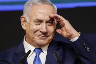 caption: Israeli Prime Minister Benjamin Netanyahu gestures as he addresses supporters at his Likud Party headquarters in Tel Aviv on election night early on Wednesday.