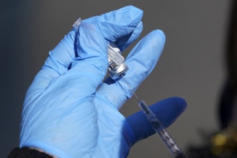 caption: A nurse fills a syringe with COVID-19 vaccine at a mass vaccination site in Kansas City, Mo. on March 19, 2021.