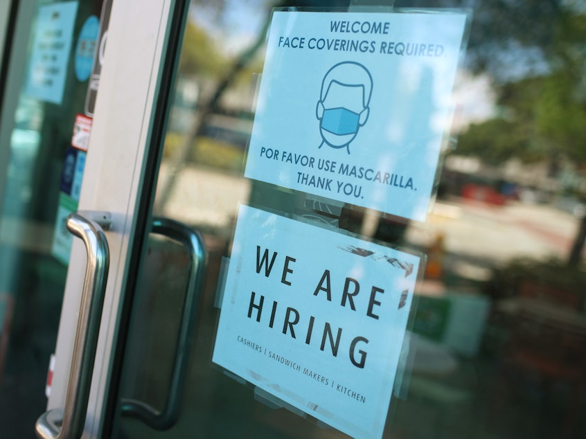 caption: A store in Miami displays a "We are hiring" sign on March 5. U.S. employers added 916,000 jobs in March, the biggest number since August, amid an improving pandemic outlook and trillions of dollars in stimulus passed by Congress.
