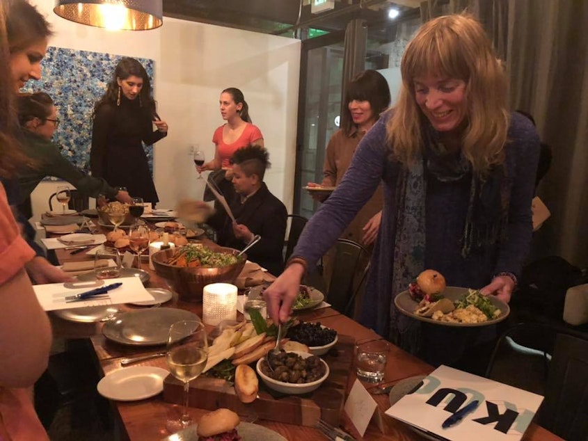 caption: Jennifer Hegeman (foreground) scooping up olives at The Cloud Room in Seattle during KUOW's first Curiosity Club dinner on January 17, 2019. 
