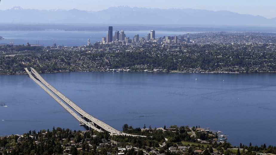 caption: In this photo taken July 28, 2014, the Olympic mountains and downtown Seattle stand behind as the I-90 floating bridge is in view from Mercer Island, Wash., bottom, across Lake Washington toward Seattle. 